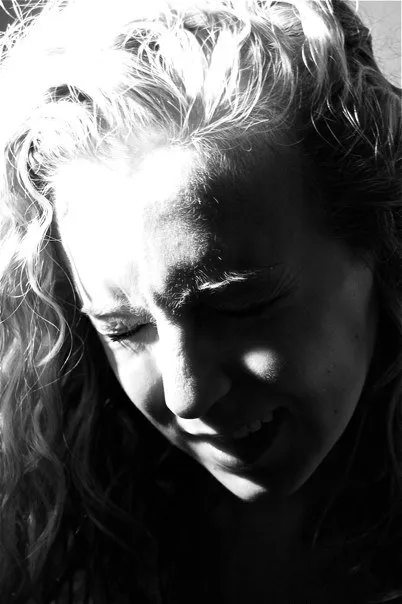 A black and white photo of a woman with curly hair.