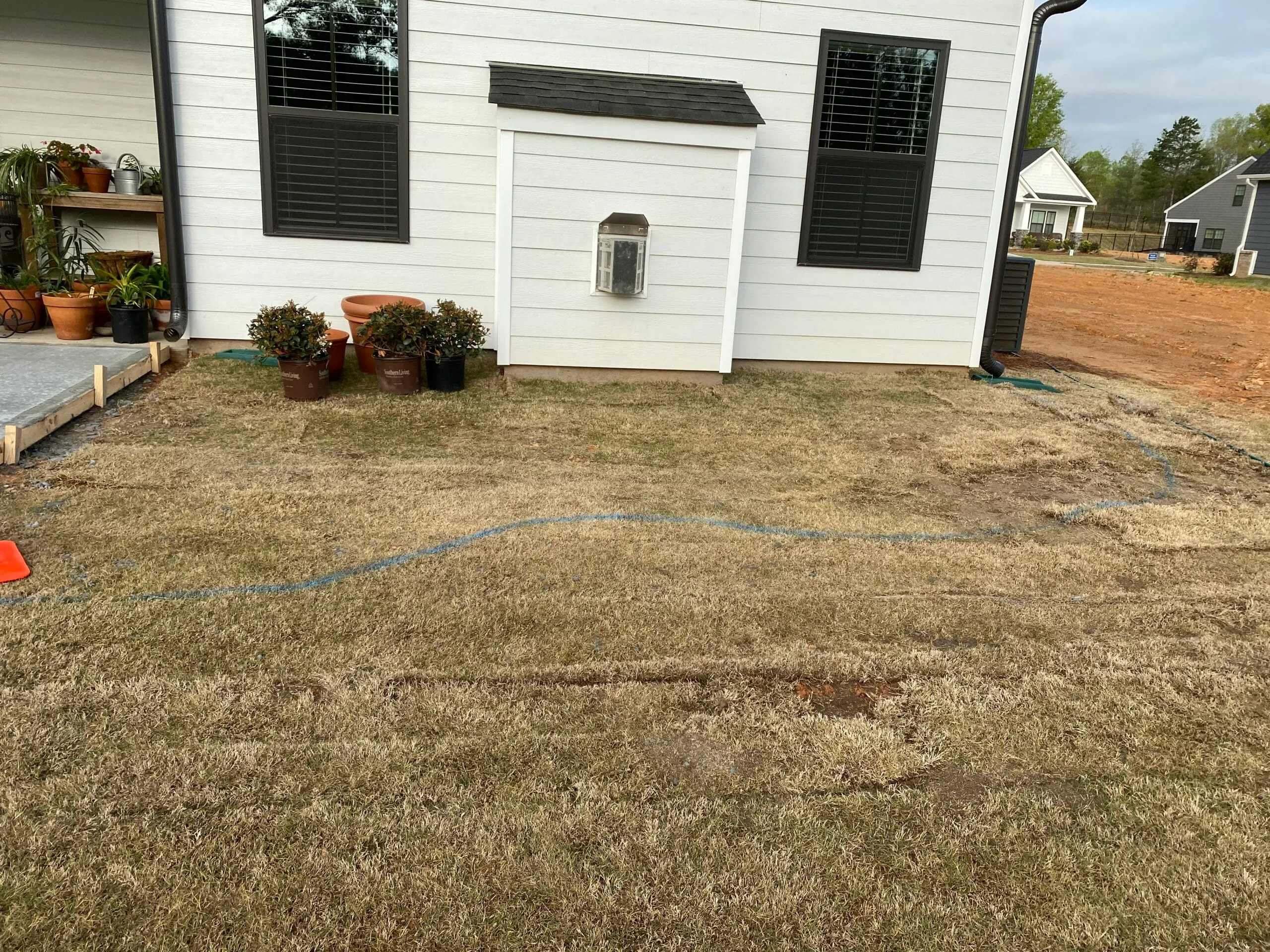 outline of new bed using a garden hose across the ground