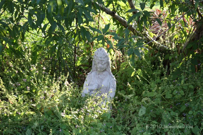 A statue of a buddha in a garden.