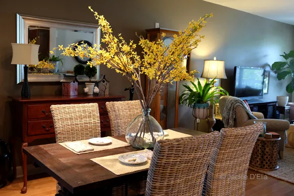 Dining room table with centerpiece of organic glass vase with yellow flowers