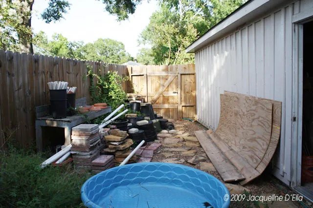 A backyard with a pool and a fence.