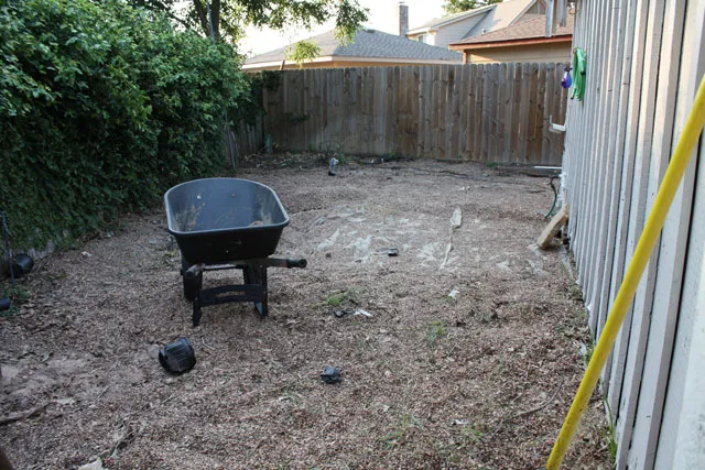 A yard with a wheelbarrow in it.