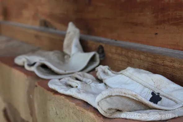 A pair of white gloves sitting on a brick wall.