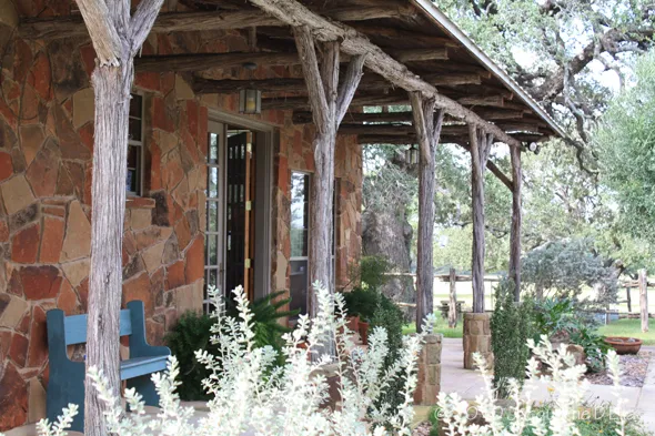 A wooden bench on the porch of a house.