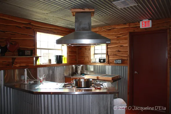 A kitchen with a stove and a hood.