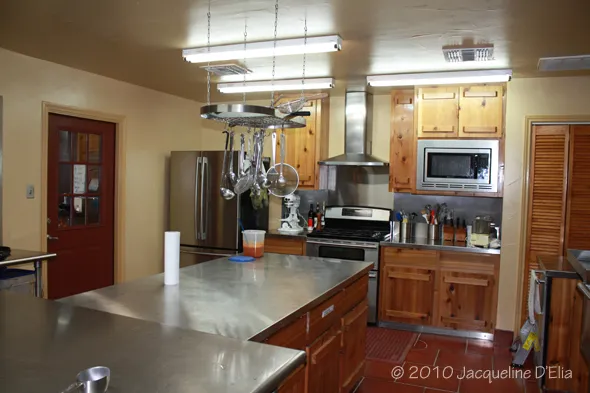 A kitchen with a stainless steel counter top and stainless steel appliances.