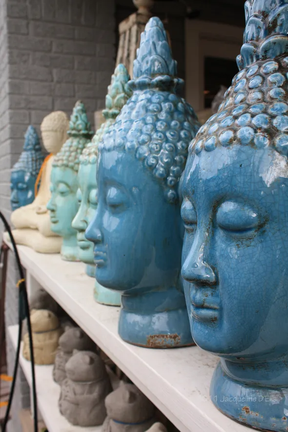 A row of blue buddha heads on a shelf.