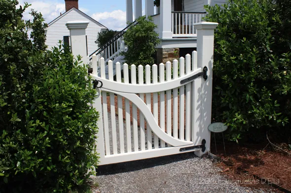 A white picket gate in front of a house.
