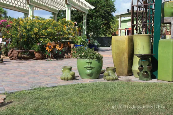 A green terracotta pot with a face on it.
