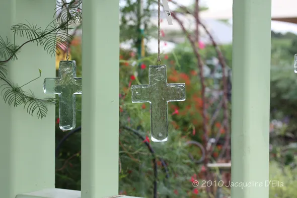 Glass cross ornaments hanging from a railing.