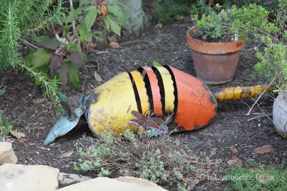A tin can sitting on the ground in a garden.