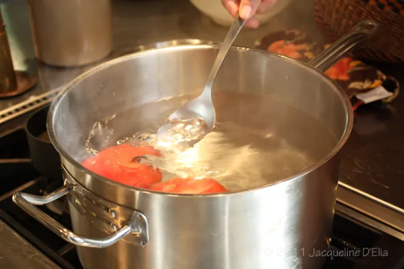 A person is canning tomatoes.