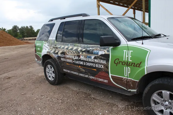 A suv is parked in front of a pile of dirt.