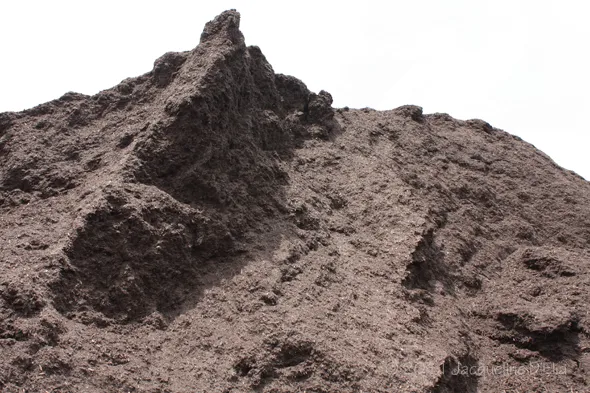 A pile of brown dirt with a white sky in the background.