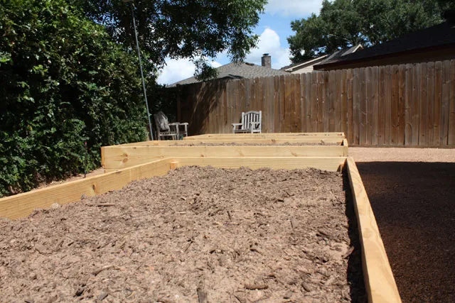 A raised garden bed in a backyard.