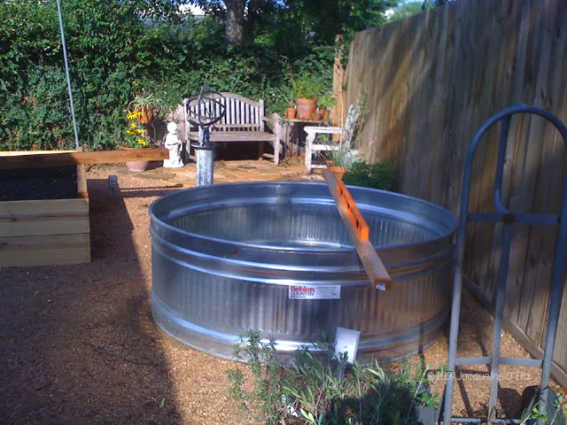 A large metal tub in a backyard.