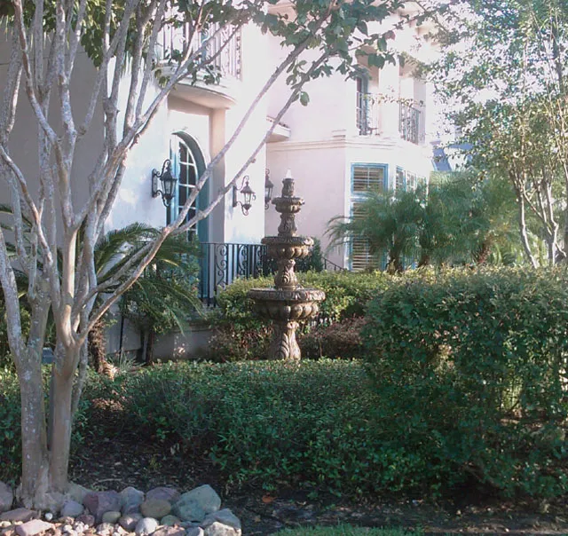 A water fountain in front of a house.