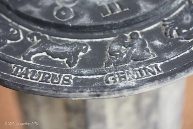A clock with a zodiac sign on it.
