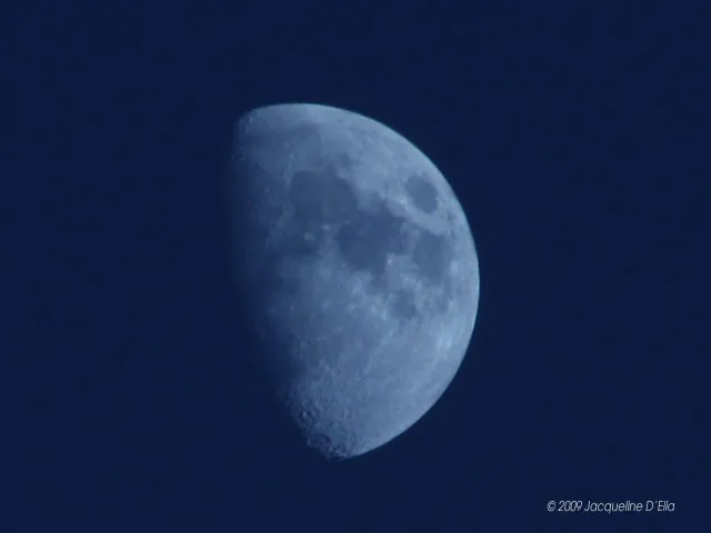 The moon is seen in the blue sky.