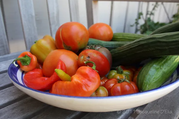 A bowl full of vegetables on a wooden table.