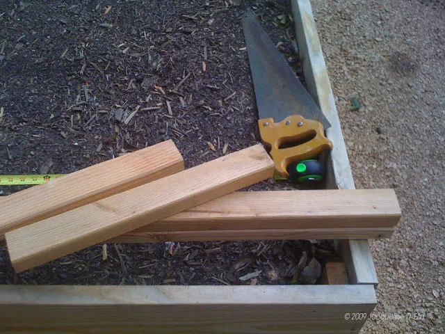 A pair of garden shears next to a vertical trellis.