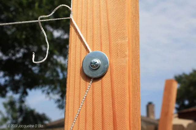 A wooden post with a vertical metal hook attached to it.